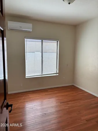 a view of an empty room with wooden floor