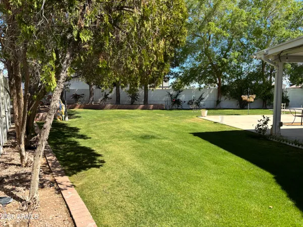 a view of a patio with table and chairs under an umbrella