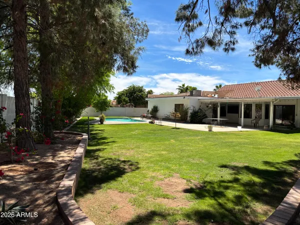 a view of a house with swimming pool and a yard