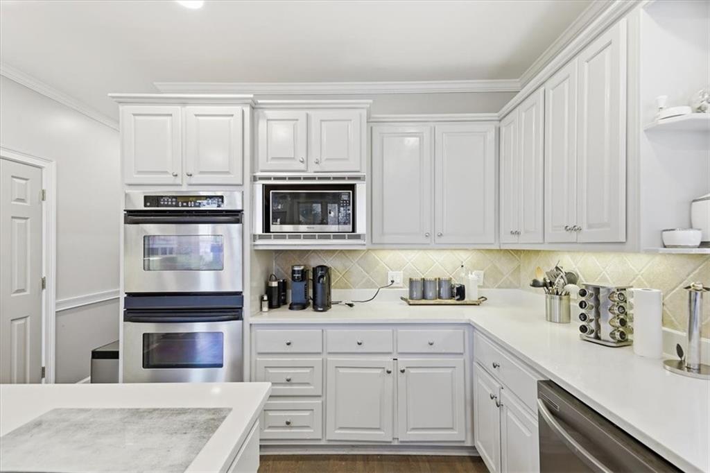 1121 Hiddenbrook Lane Suwanee, GA 30024 - Photo 16 of 42 a kitchen with white cabinets and appliances