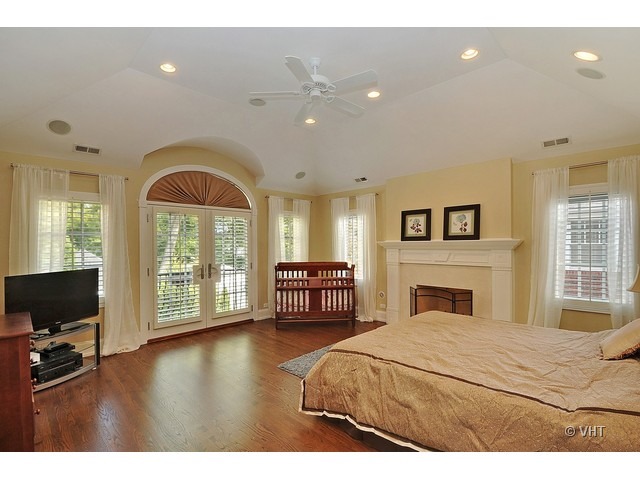 459 Sunset Road Winnetka, IL 60093 - Photo 12 of 16 a bedroom with a bed a flat screen tv and a large window with the outer view