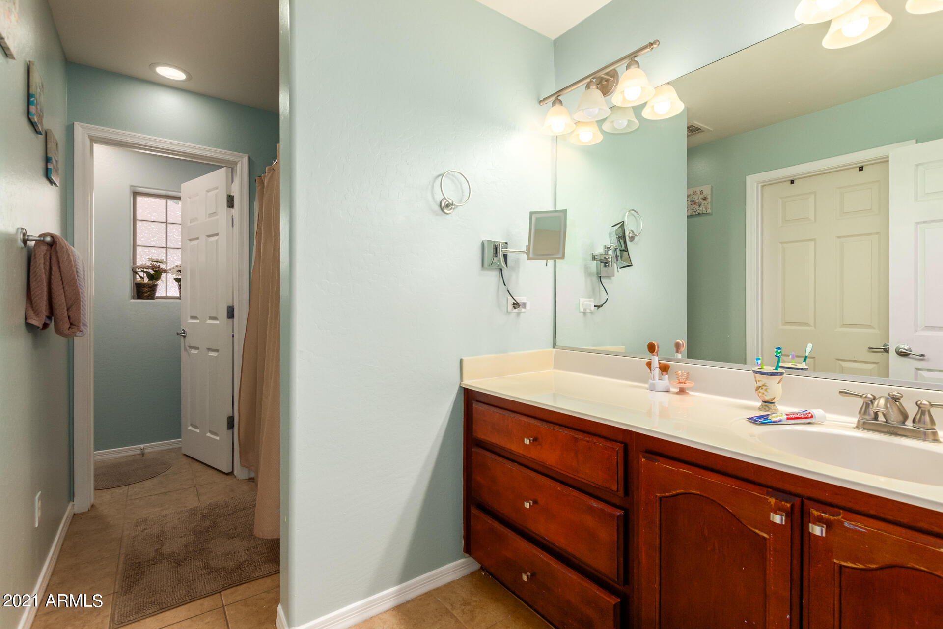 10225 West Camelback Road, Unit 8 Phoenix, AZ 85037 - Photo 24 of 30 a bathroom with a double vanity sink a mirror and a shower