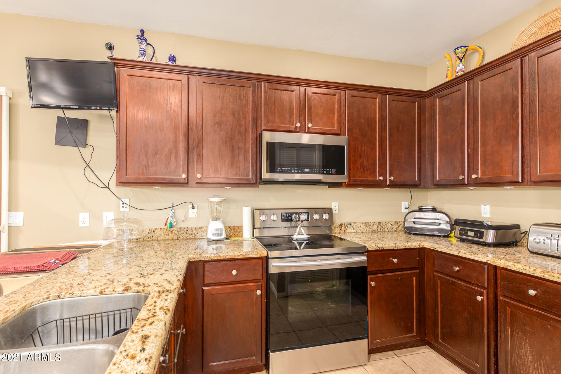 10225 West Camelback Road, Unit 8 Phoenix, AZ 85037 - Photo 9 of 30 a kitchen with stainless steel appliances granite countertop a sink stove and microwave
