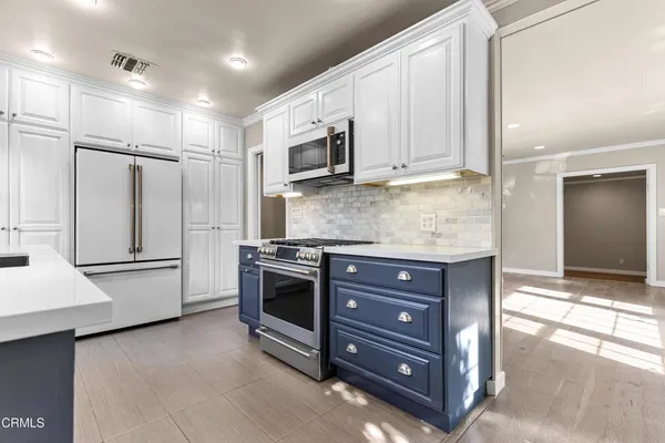 a kitchen with stainless steel appliances granite countertop a refrigerator and a stove top oven