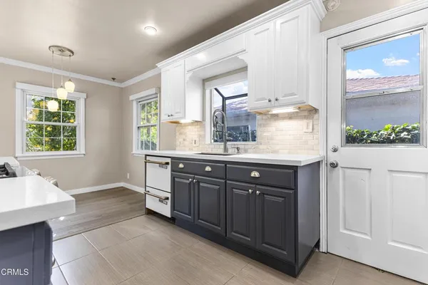 a bathroom with a granite countertop sink mirror and window