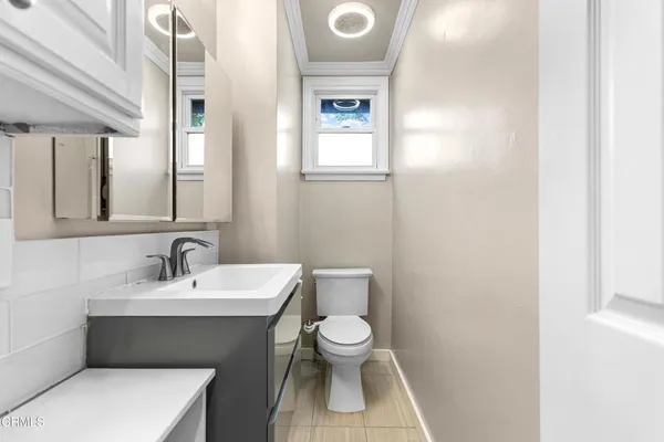 a bathroom with a toilet a sink and mirror