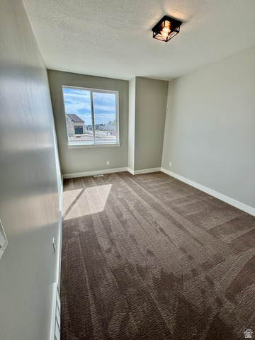 1184 West 3250 North Ogden, UT 84414 - Photo 45 of 69 Light-filled room featuring a large window, neutral wall paint, patterned carpet flooring, and a contemporary ceiling light fixture