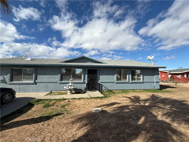 a house view with a sitting space fire pit and outdoor space