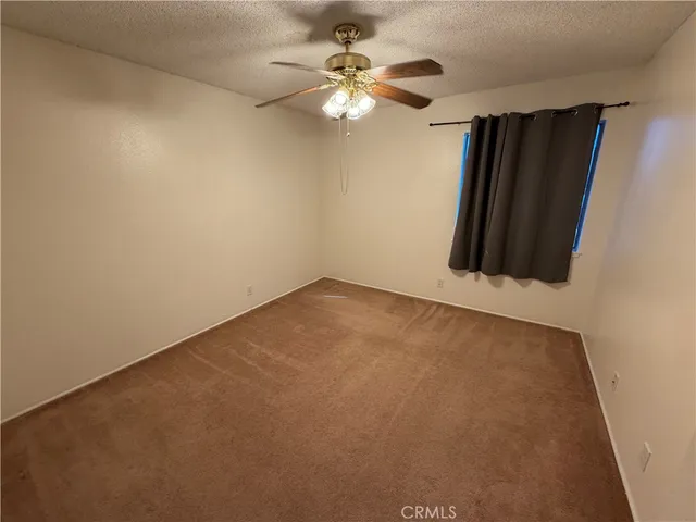 an empty room with windows and fan