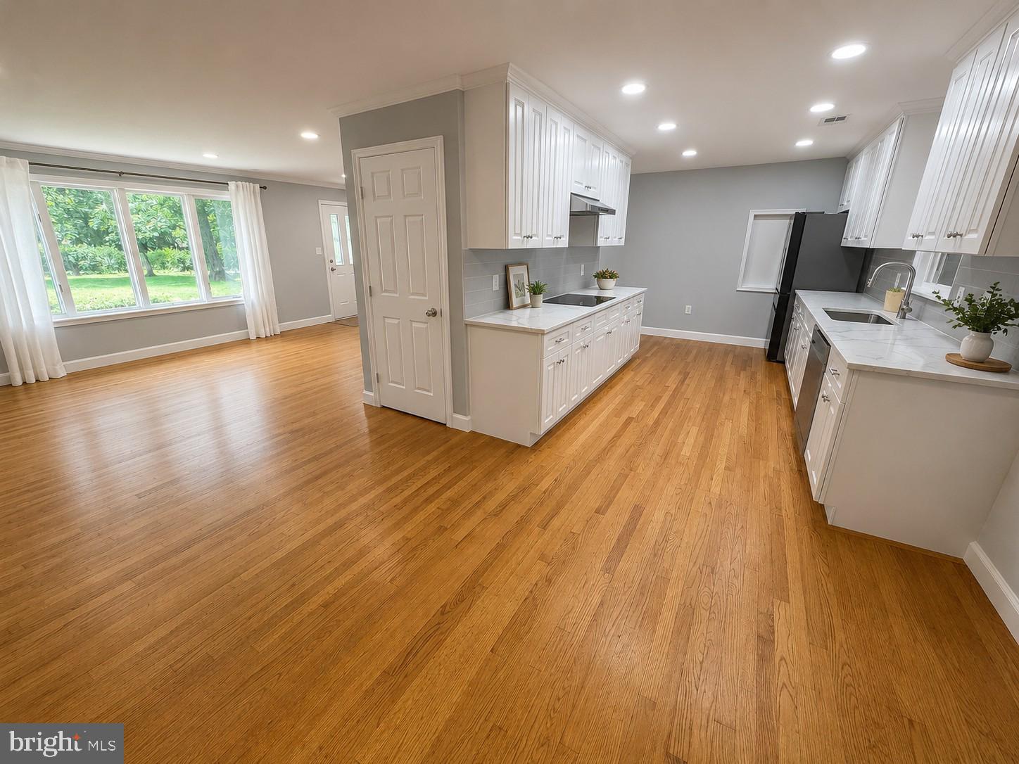 12658 Scaggsville Road Highland, MD 20777 - Photo 8 of 13 a large white kitchen with wooden floors and stainless steel appliances