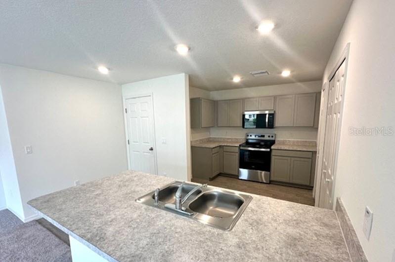 9 Ripton Place Palm Coast, FL 32164 - Photo 3 of 14 a kitchen with a refrigerator sink and stove