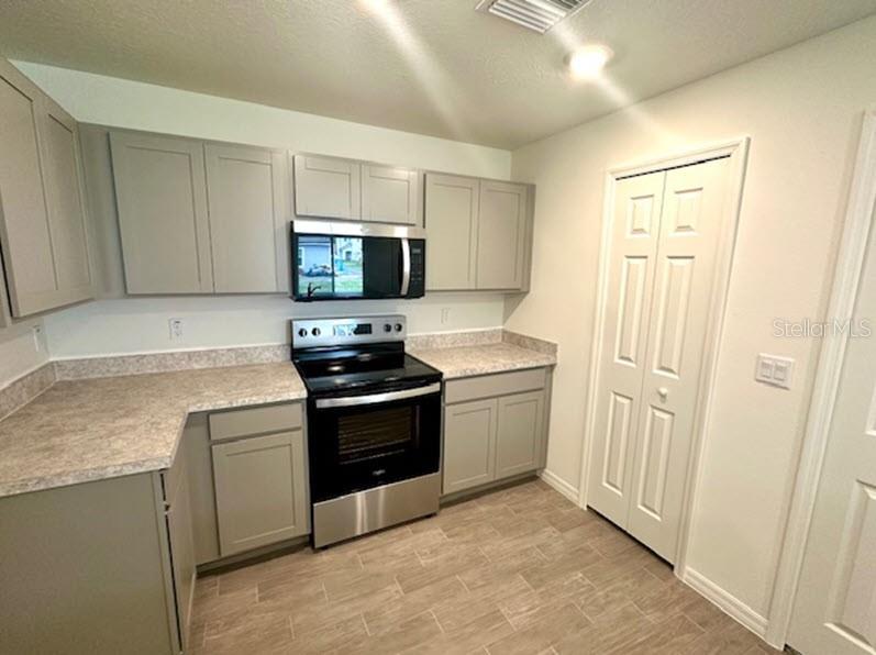 9 Ripton Place Palm Coast, FL 32164 - Photo 4 of 14 a kitchen with stainless steel appliances granite countertop a stove a sink and a refrigerator