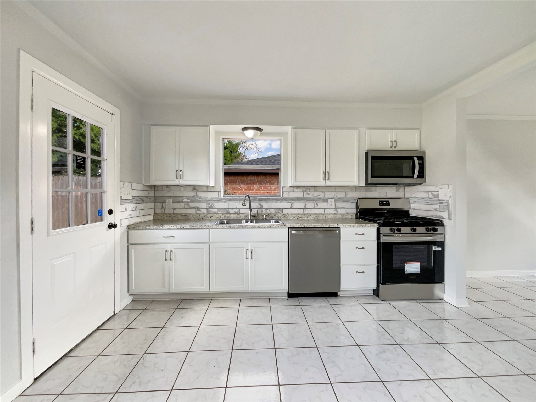 205 Bastrop Street Angleton, TX 77515 - Photo 2 of 18 a kitchen with a stove a sink and a microwave
