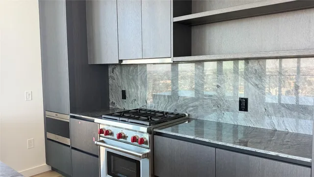 a kitchen with stainless steel appliances granite countertop a stove and a microwave