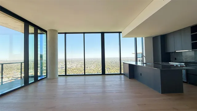 a view of a kitchen with stainless steel appliances wooden floor and a large window