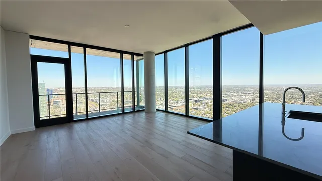 a view of a hardwood floor and windows in a room