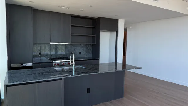 a kitchen with granite countertop a sink and a stove