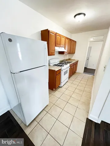 a kitchen with granite countertop a refrigerator and a stove top oven