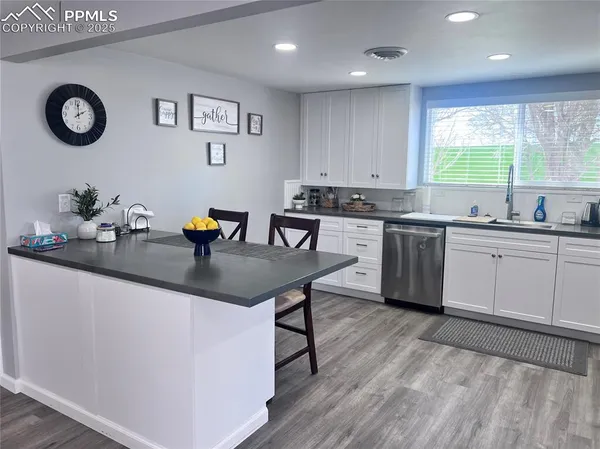 a kitchen with a sink chairs and cabinets