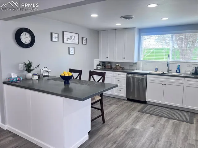 a kitchen with a sink chairs and cabinets