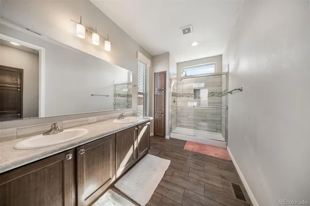 a bathroom with a granite countertop toilet and a shower