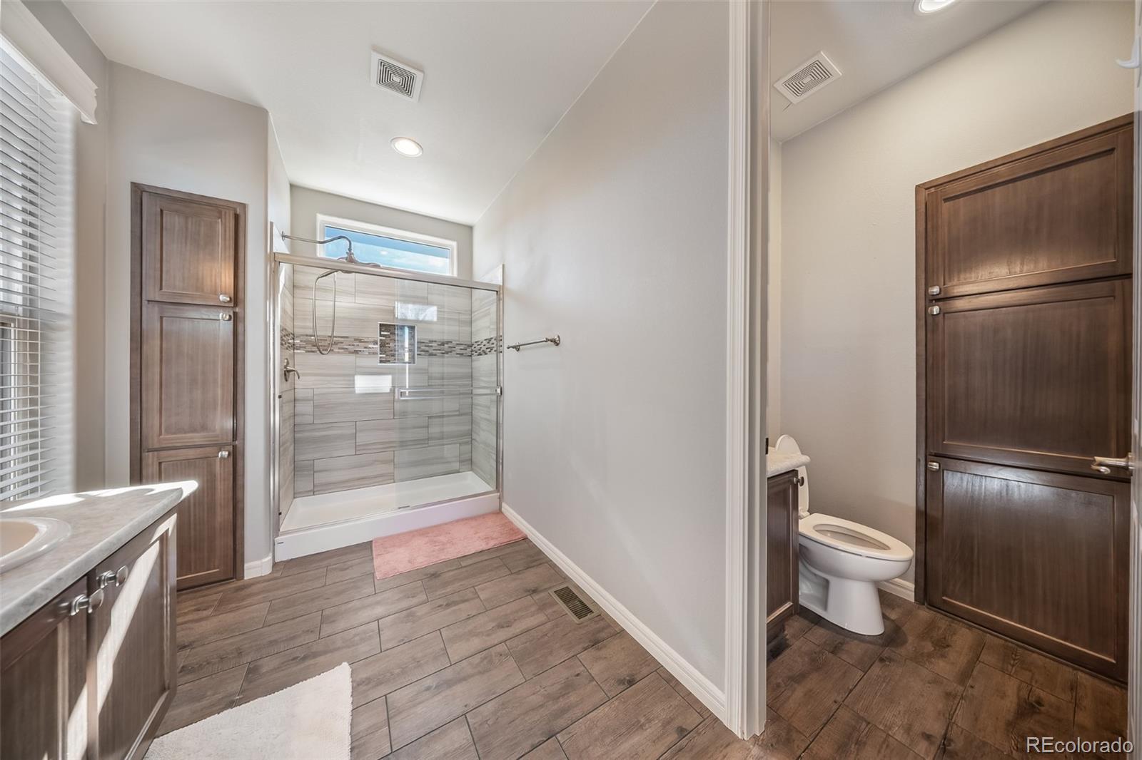 551 Summit Trail Granby, CO 80446 - Photo 17 of 35 a bathroom with a granite countertop toilet and a shower