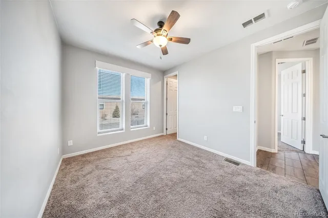 an empty room with fan and windows