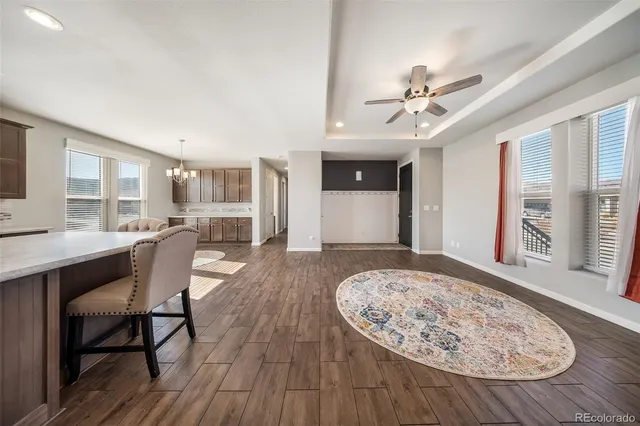 a kitchen with stainless steel appliances a stove a sink a microwave a refrigerator white cabinets and wooden floor