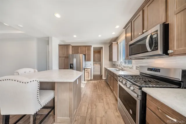 a kitchen with stainless steel appliances granite countertop a stove a sink and a microwave