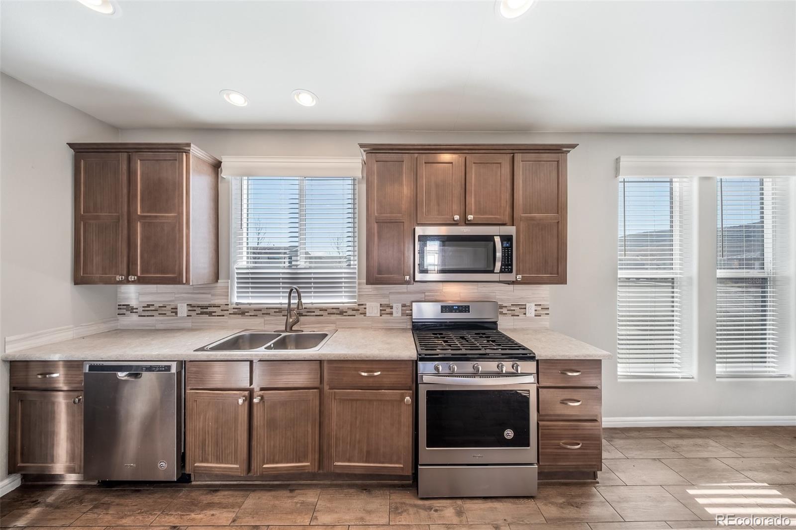 551 Summit Trail Granby, CO 80446 - Photo 7 of 35 a kitchen with stainless steel appliances granite countertop a stove a sink and a microwave