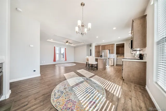 a view of a livingroom with wooden floor and kitchen space