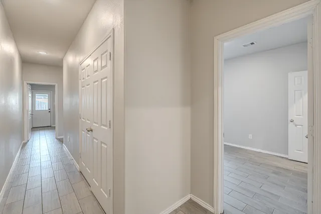 a view of a hallway with wooden floor