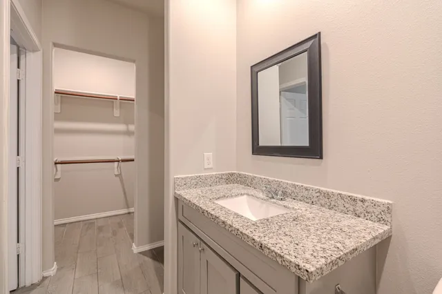a bathroom with a granite countertop sink and a mirror