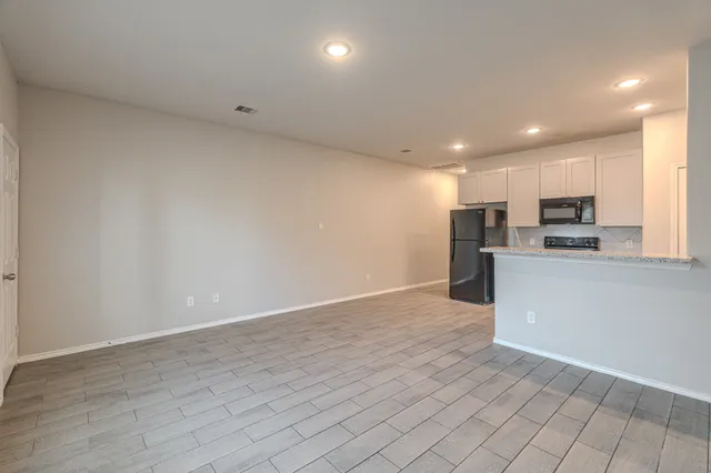a view of kitchen with kitchen island microwave and cabinets