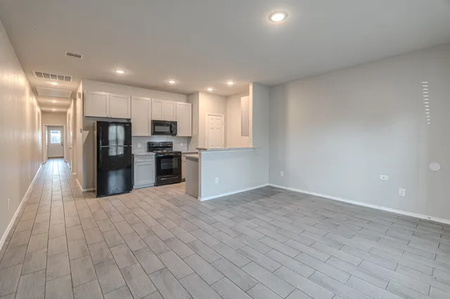 a view of a kitchen with refrigerator and wooden floor