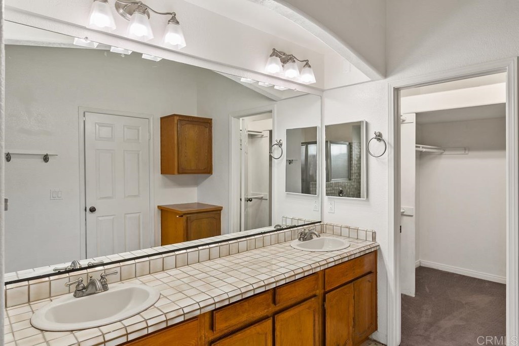 2248 Winsome Place Escondido, CA 92029 - Photo 19 of 26 a bathroom with a granite countertop sink a mirror and shower