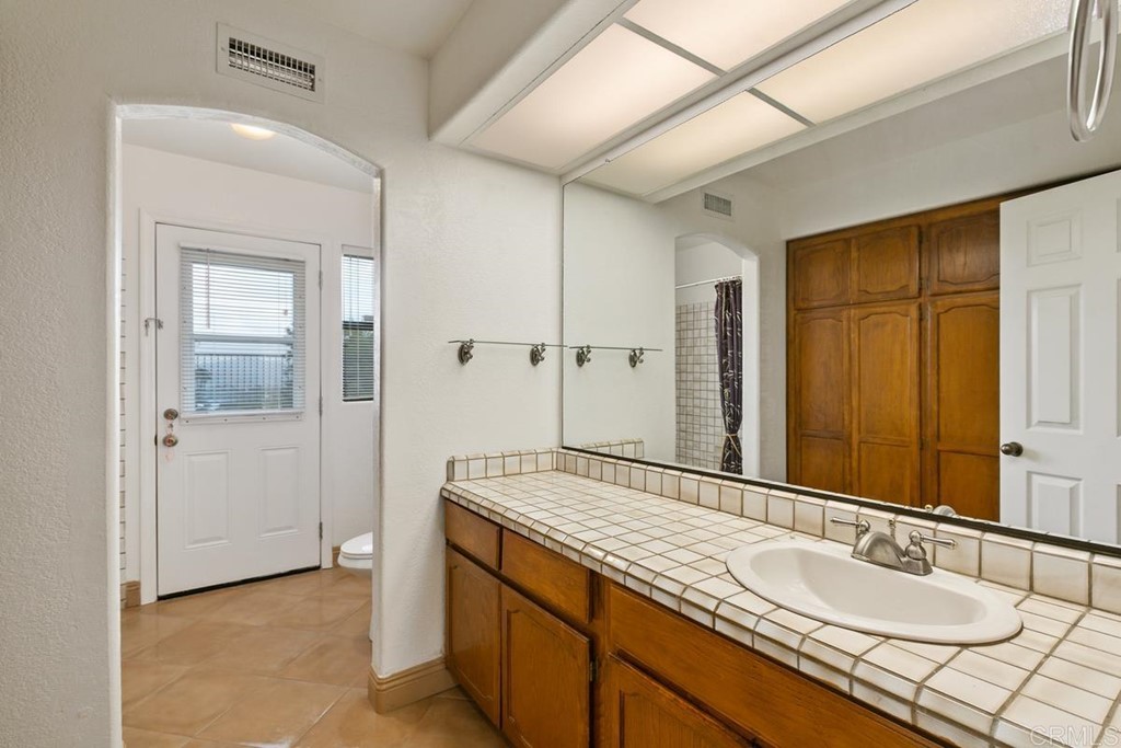 2248 Winsome Place Escondido, CA 92029 - Photo 22 of 26 a bathroom with a granite countertop sink and a mirror