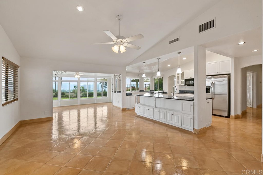 2248 Winsome Place Escondido, CA 92029 - Photo 8 of 26 a large white kitchen with kitchen island a large window and stainless steel appliances