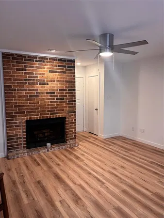 a view of empty room with wooden floor and fireplace