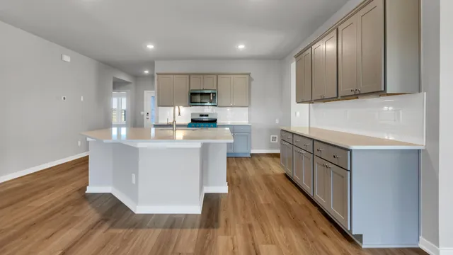 a kitchen with kitchen island granite countertop wooden floors and stainless steel appliances