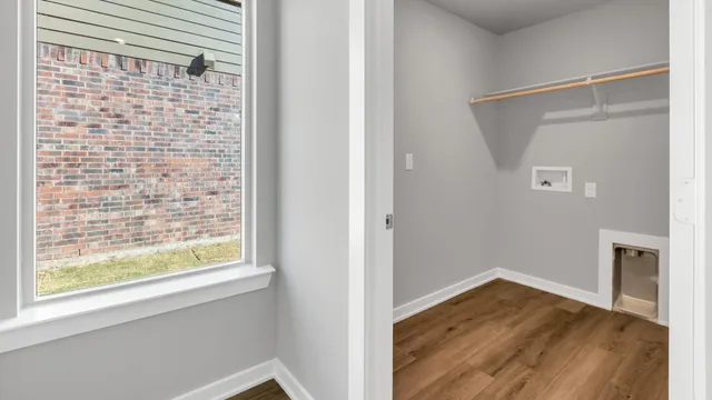 a view of a livingroom with wooden floor and a window