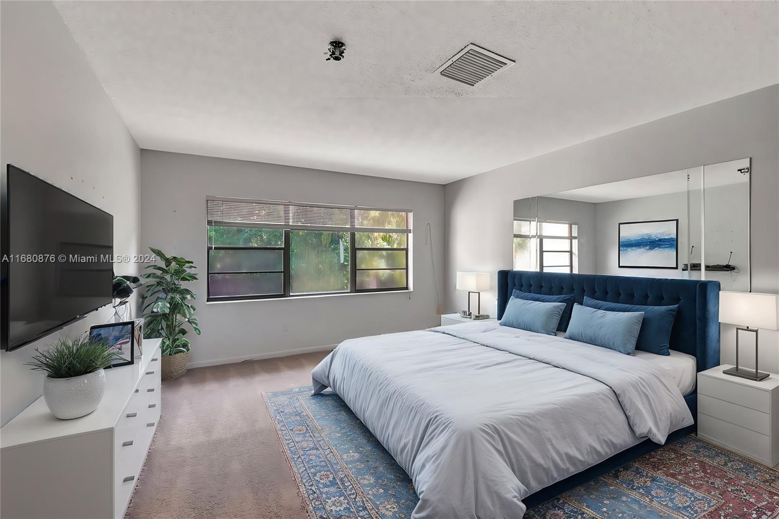 21864 Arriba Real, Unit 3E Boca Raton, FL 33433 - Photo 27 of 61 a bedroom with a large bed and a flat screen tv