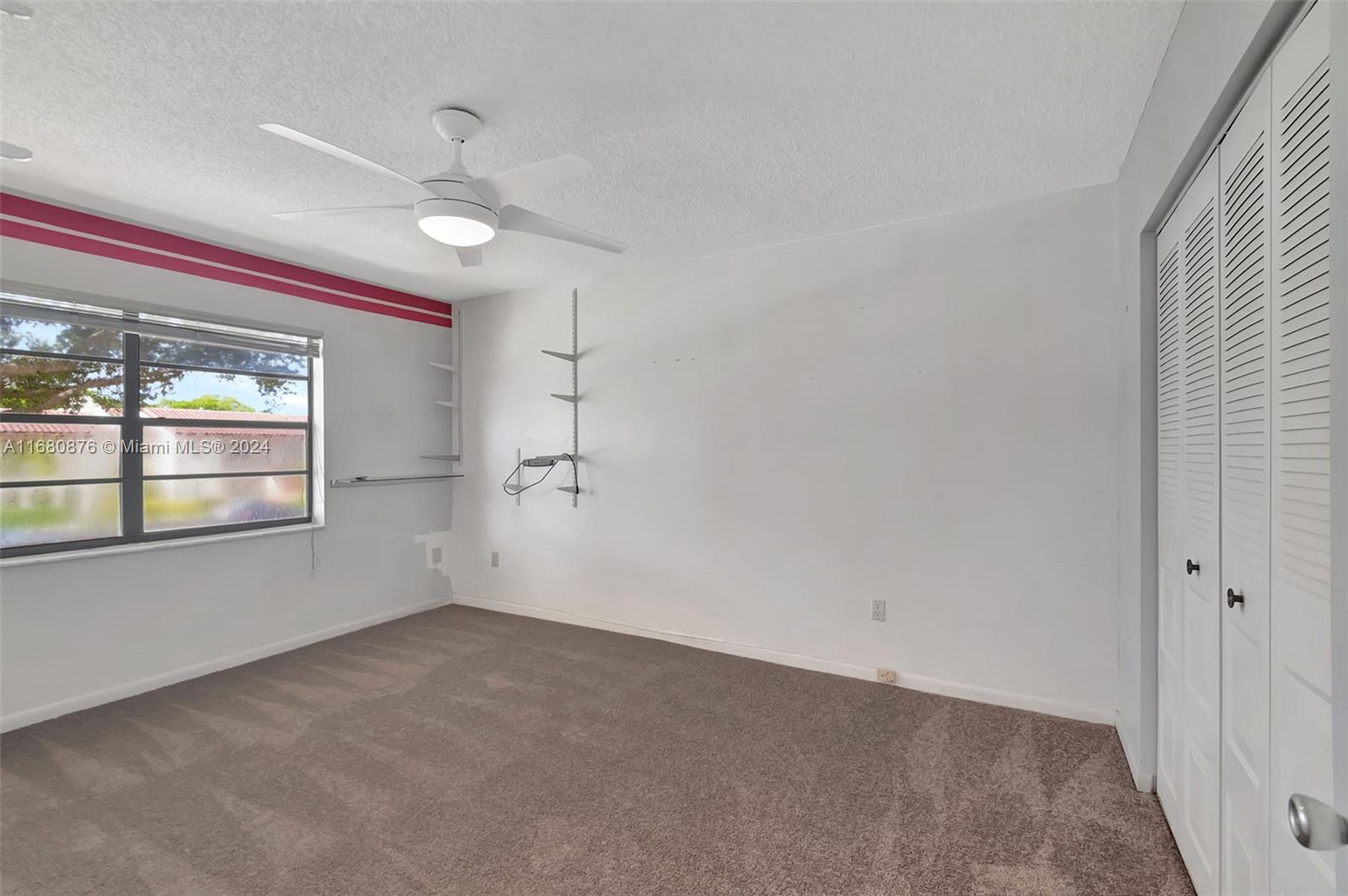 21864 Arriba Real, Unit 3E Boca Raton, FL 33433 - Photo 33 of 61 an empty room with a ceiling fan and windows