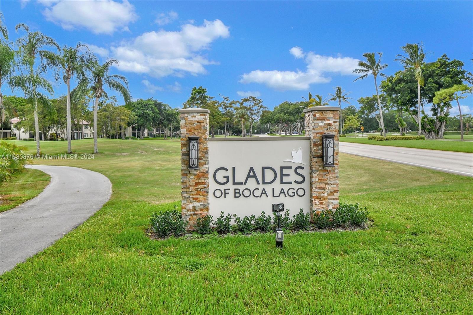 21864 Arriba Real, Unit 3E Boca Raton, FL 33433 - Photo 44 of 61 a sign that is sitting on the grass next to a building