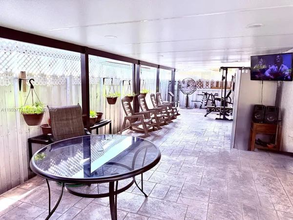 a dining room with furniture and a floor to ceiling window