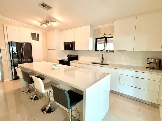 a kitchen with a sink refrigerator and cabinets