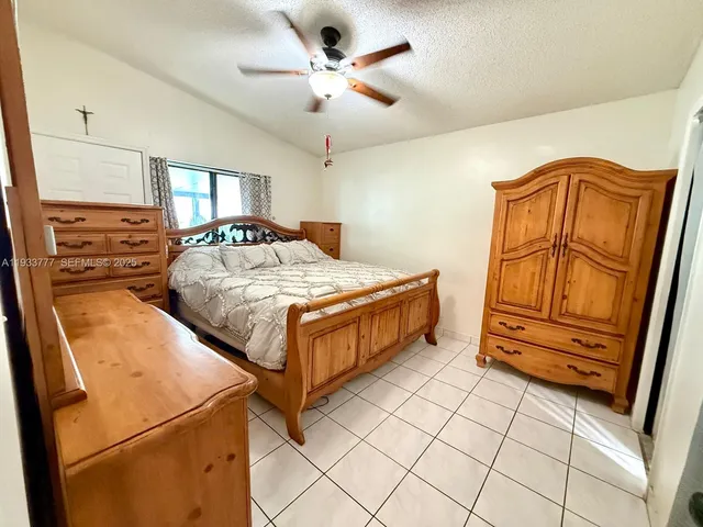 a bedroom with a bed and a dresser with wooden floor