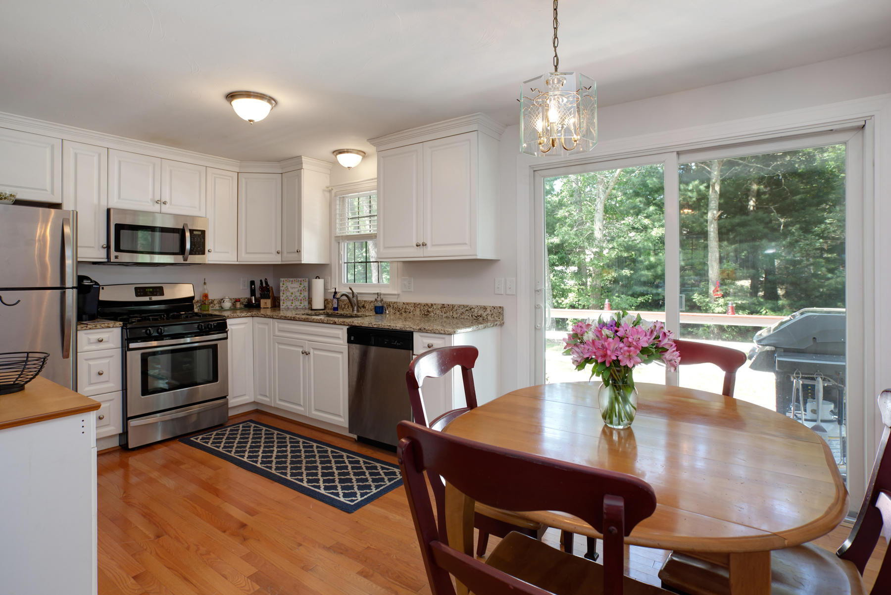 291 Skunknet Road Centerville, MA 02632 - Photo 9 of 39 a kitchen with microwave a stove a table and chairs