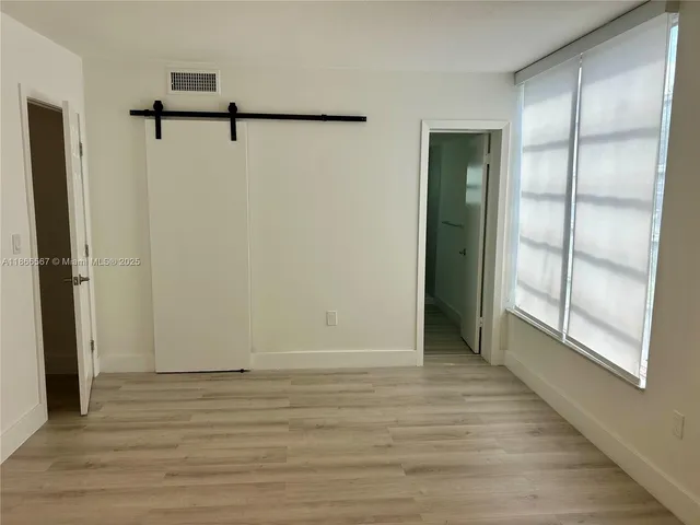 a view of a room with wooden floor and windows