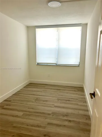 a view of a room with wooden floor and window